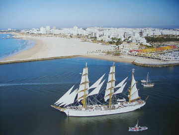 Die Gorch Fock beim Auslaufen aus dem Hafen von Portim&atilde;o im April 2005 - im Hintergrund Praia Rocha